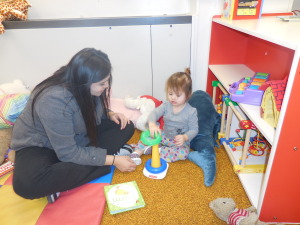 An adult and a child playing with toys.